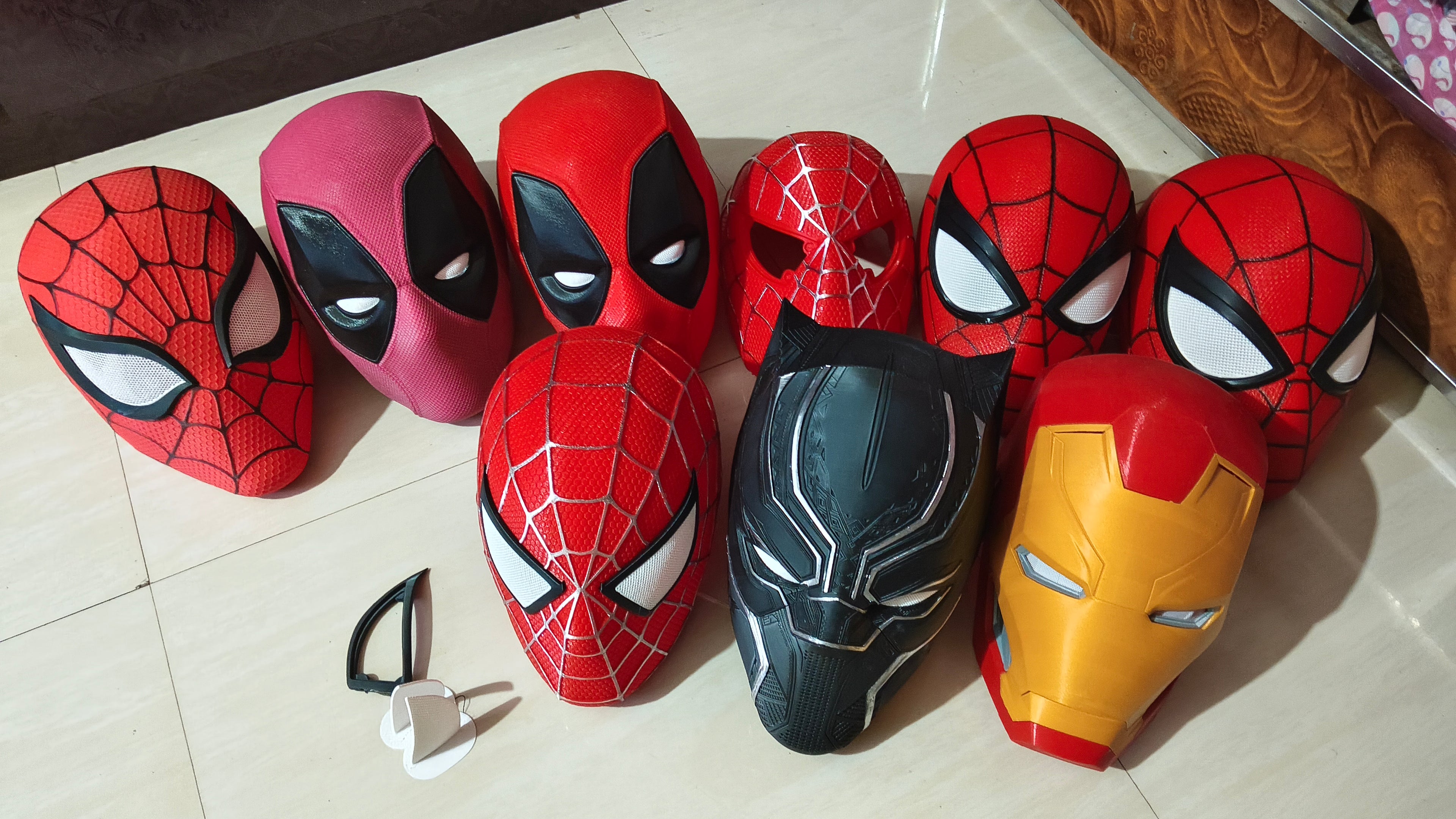 Collection of superhero masks on a tiled floor